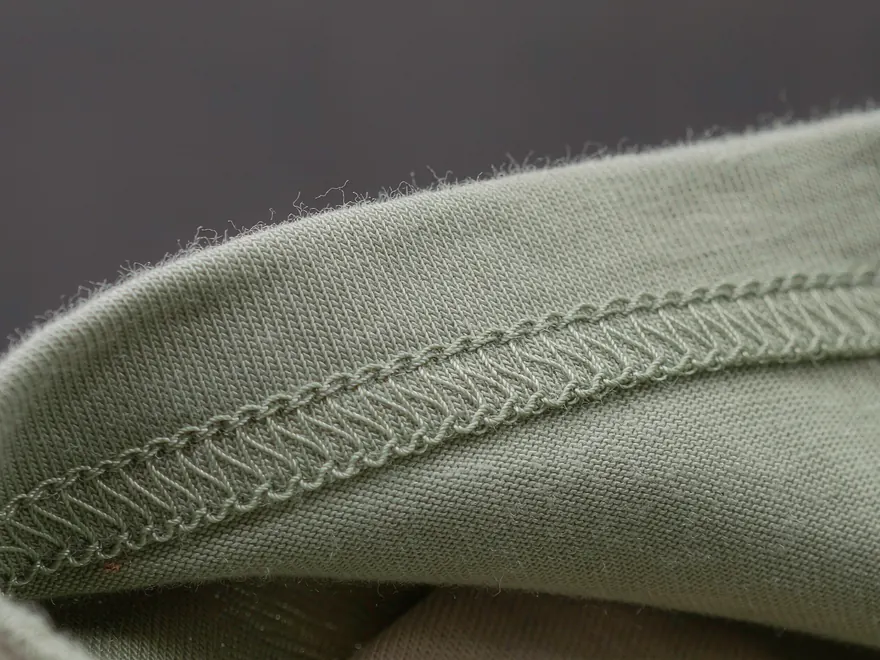 Makroansicht eines gleichmäßig überdeckten Saums an einem Strickstück.